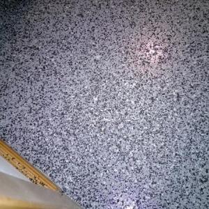 Grauer Bodenbelag mit feiner, unregelmäßiger schwarzer und weißer Maserung